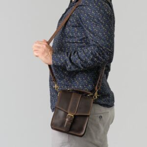 δερμάτινο ανδρικό τσαντάκι με αποσπώμενο λουρί για χιαστί κράτημα διαθέτει επίσης και χεράκια στην πάνω μεριά. καφέ λαδιού σκούρο χρώμα